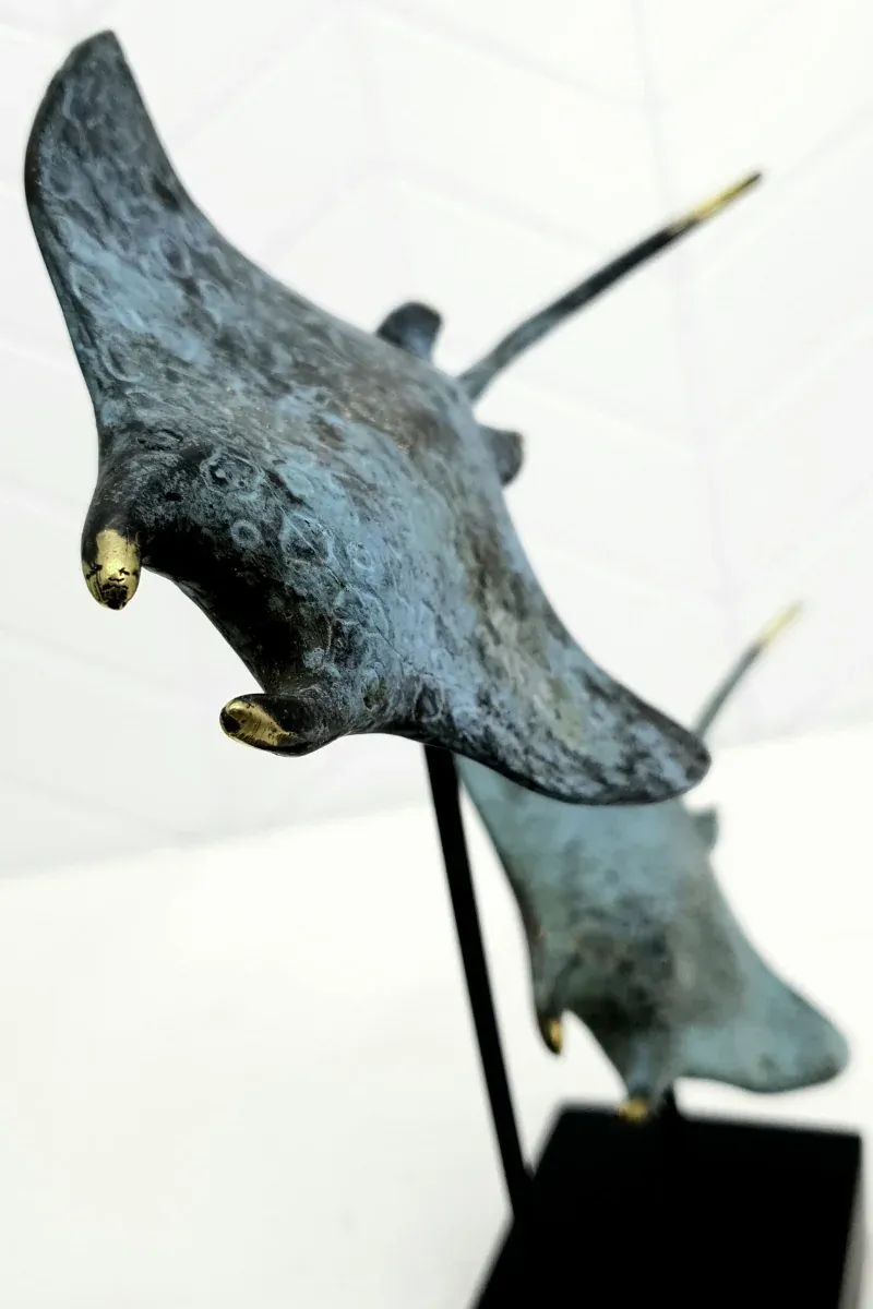 Hand-gilded detail on patinated bronze — the Twin Manta Ray sculpture up close